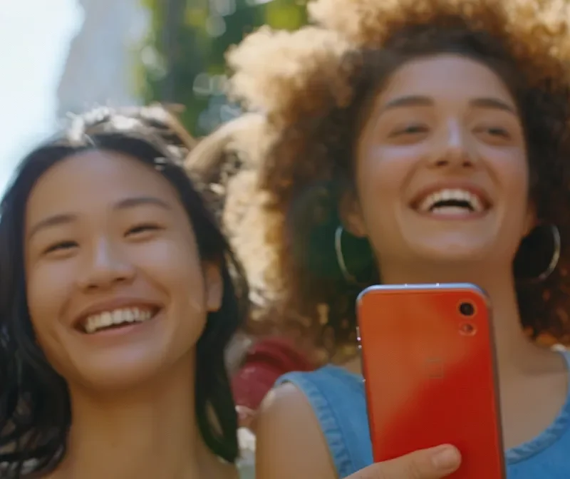 a diverse group of people smiling and engaging with a variety of engaging and colorful facebook ads on their phones.